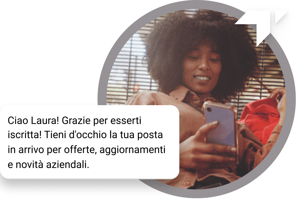 Una ragazza dai capelli ricci seduta sul pavimento controlla il suo telefono per vedere il messaggio di “Grazie” ricevuto per la sua iscrizione.
