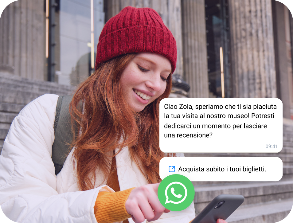 Ragazza con un berretto rosso che legge un messaggio aziendale di WhatsApp sul suo telefono