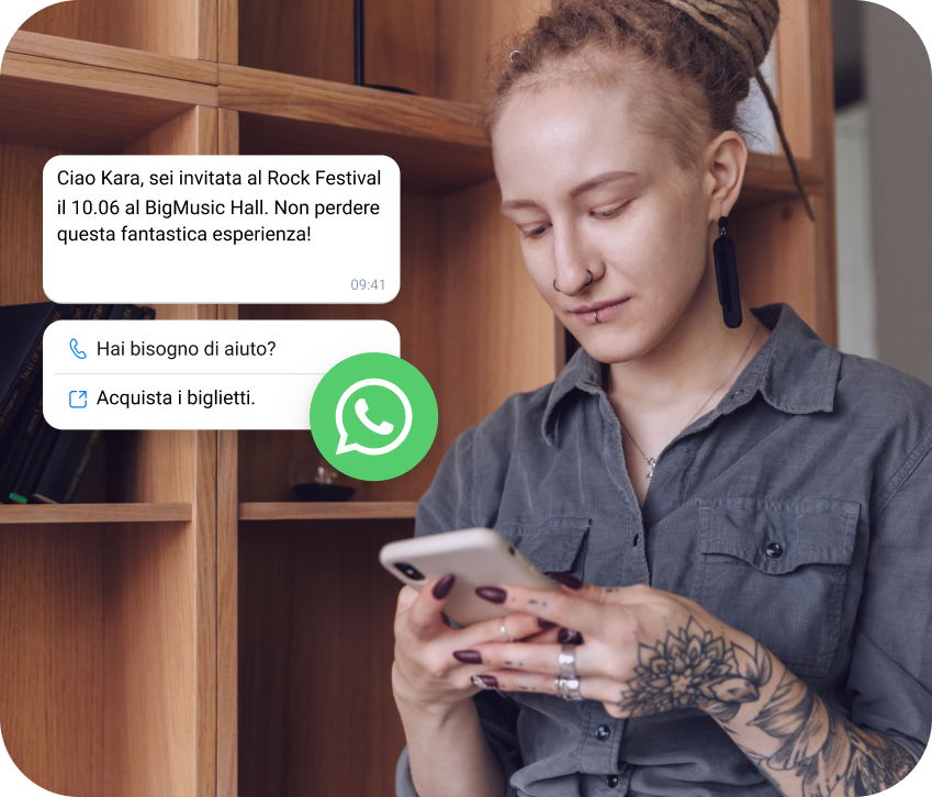 Ragazza con un tatuaggio che controlla sul telefono l'invito a un festival rock ricevuto tramite WhatsApp